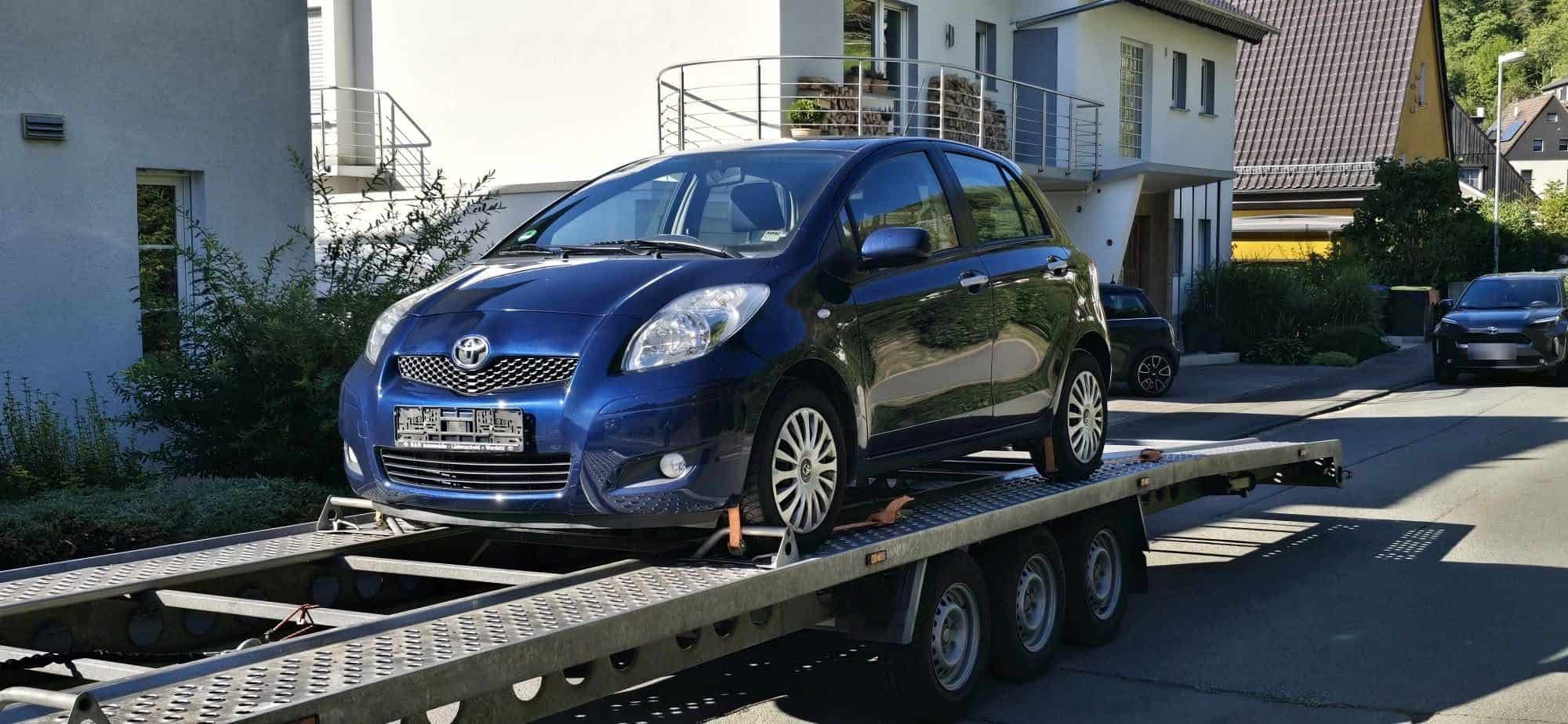 Blauwe Toyota Yaris op de autoaanhanger, opgehaald in Duitsland
